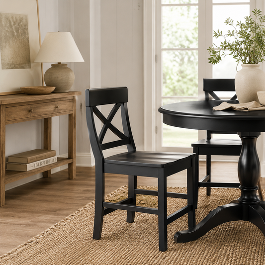 Black dining table with chairs in a room with a lamp and plant.